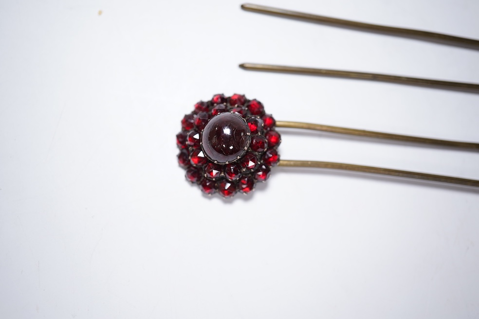 A Victorian yellow metal and garnet cluster set open work brooch, 27mm, together with two garnet cluster set hair ornaments. Condition - poor to fair